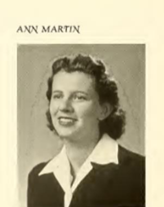 A black and white picture of Ann Martin. She had shoulder length hair and wears a black shirt with a large white collar. 