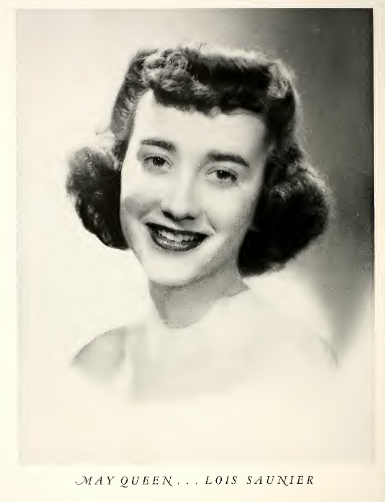 A black and white picture that shows May Queen Lois Saunier Hornsby from the shoulders up. She has the front of her hair pulled back and it puffs out around her ears. She is smiling, showing her teeth.