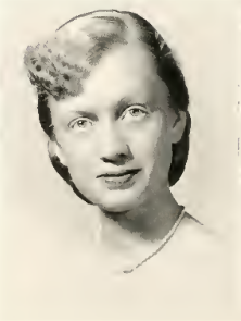 A black and white picture of Dorothy "Dot" Reisig. She is wearing a necklace and her hair is pulled back, except for the curls falling over the left side of her forehead.